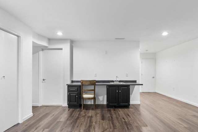 indoor wet bar with dark wood-style flooring, recessed lighting, and baseboards