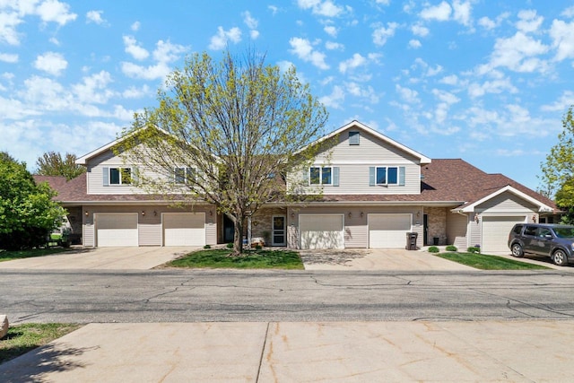 view of front of house featuring driveway, a garage, and a shingled roof