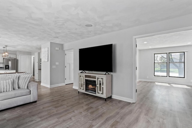 3927 Southwyck Ct, Janesville, WI 53546 - living room with wood finished floors, baseboards, a warm lit fireplace, and recessed lighting