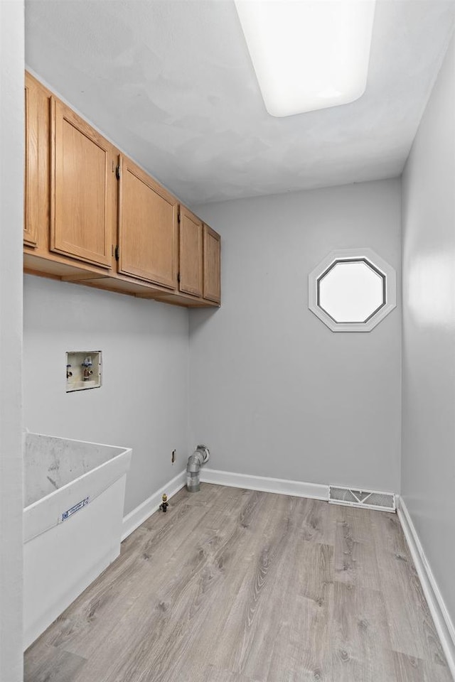 3927 Southwyck Ct, Janesville, WI 53546 - laundry area with cabinet space, hookup for a washing machine, light wood-style floors, baseboards, and gas dryer hookup