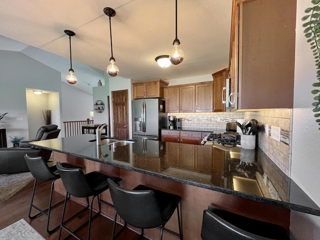 3960 Scenic Way Unit 4, Franksville, WI 53126 - kitchen featuring appliances with stainless steel finishes, a sink, backsplash, a peninsula, and hanging light fixtures