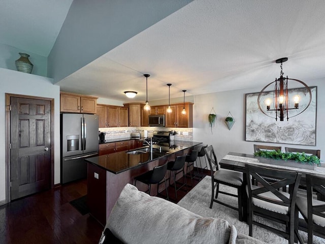 3960 Scenic Way Unit 4, Franksville, WI 53126 - kitchen featuring appliances with stainless steel finishes, a peninsula, tasteful backsplash, dark wood finished floors, and a breakfast bar area
