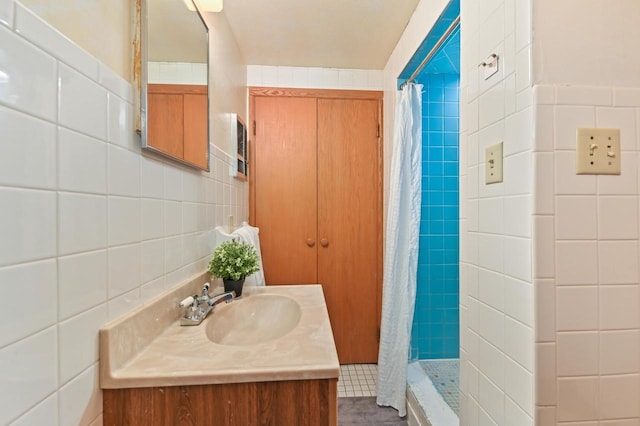 full bath with tile walls, a stall shower, and vanity