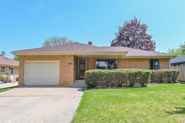 single story home with a garage, brick siding, a front lawn, and driveway
