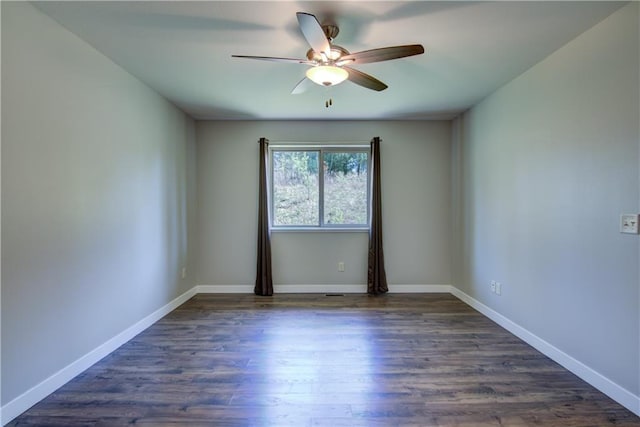 unfurnished room with a ceiling fan, dark wood-style flooring, and baseboards