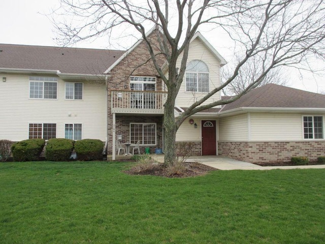 view of front of home featuring brick siding and a front lawn