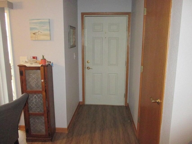 hallway with wood finished floors and baseboards
