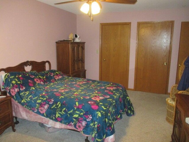 carpeted bedroom with multiple closets and ceiling fan