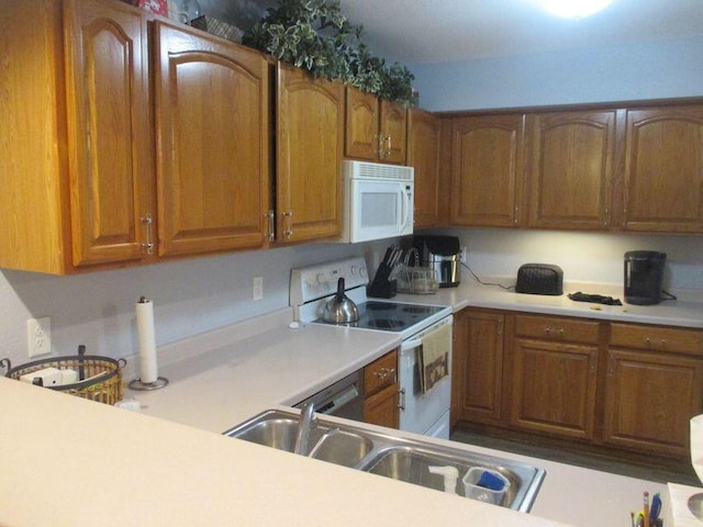 kitchen with white appliances, brown cabinetry, and light countertops