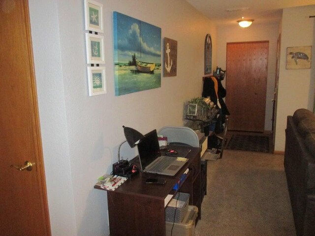 corridor featuring carpet flooring and a desk