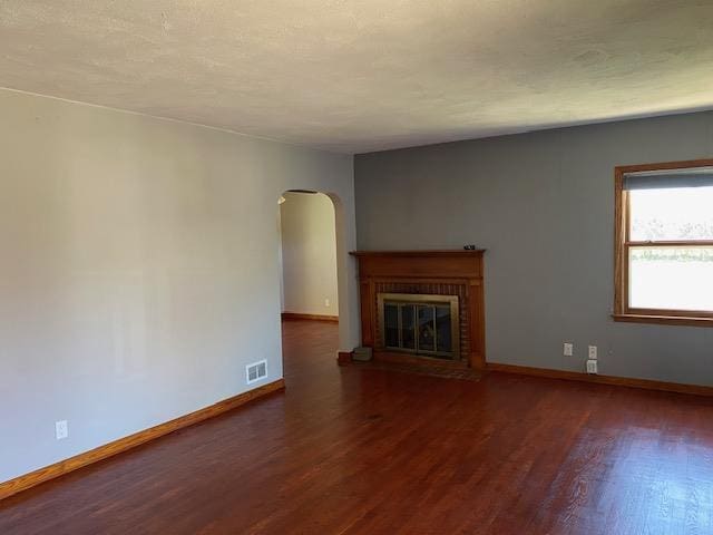 301 E Coldspring Ave, Madison, WI 53716 - unfurnished living room featuring arched walkways, wood finished floors, and baseboards