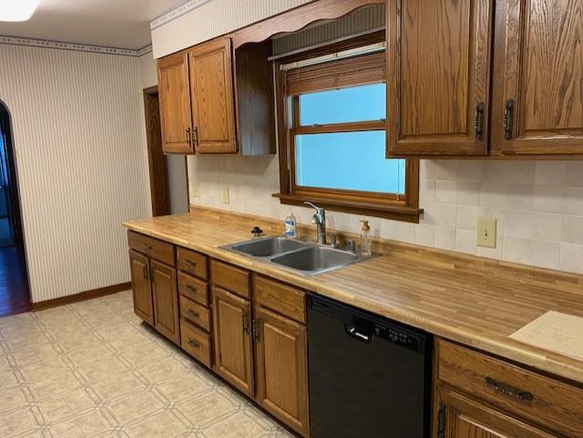 301 E Coldspring Ave, Madison, WI 53716 - kitchen featuring black dishwasher, a sink, light floors, light countertops, and tasteful backsplash
