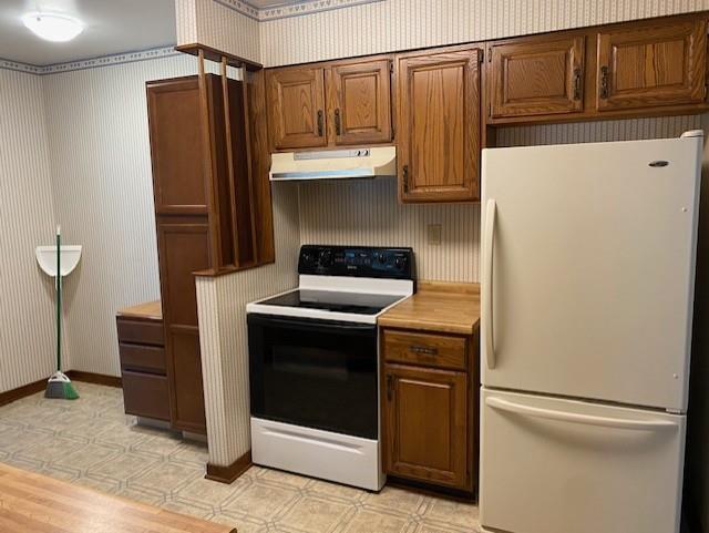 301 E Coldspring Ave, Madison, WI 53716 - kitchen with freestanding refrigerator, electric range oven, under cabinet range hood, wallpapered walls, and light countertops