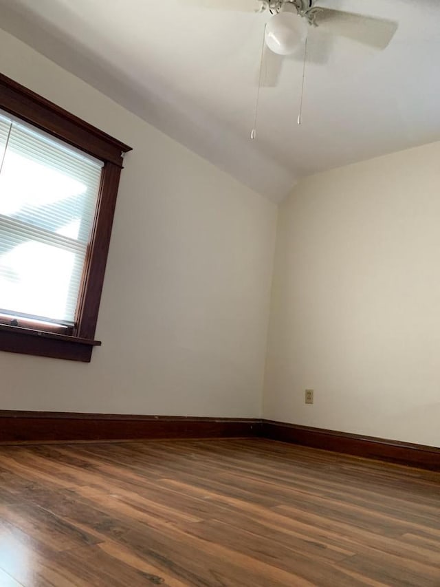 944 9th St, Beloit, WI 53511 - empty room with dark wood finished floors, baseboards, lofted ceiling, and ceiling fan