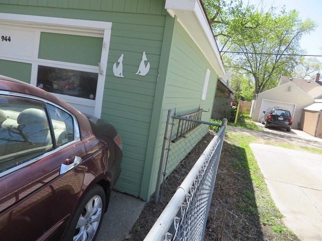 944 9th St, Beloit, WI 53511 - view of home's exterior with concrete driveway, a garage, and fence