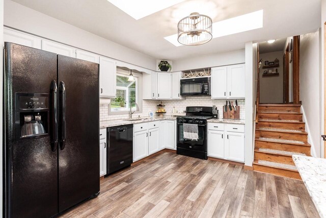 7929 N Pine View Dr, Edgerton, WI 53534 - kitchen with black appliances, white cabinets, a sink, and decorative backsplash