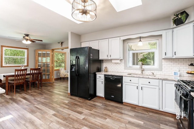 7929 N Pine View Dr, Edgerton, WI 53534 - kitchen featuring black appliances, a sink, tasteful backsplash, light stone countertops, and white cabinetry