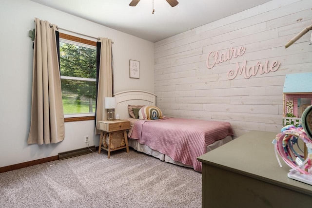 7929 N Pine View Dr, Edgerton, WI 53534 - carpeted bedroom featuring wood walls, ceiling fan, and baseboards