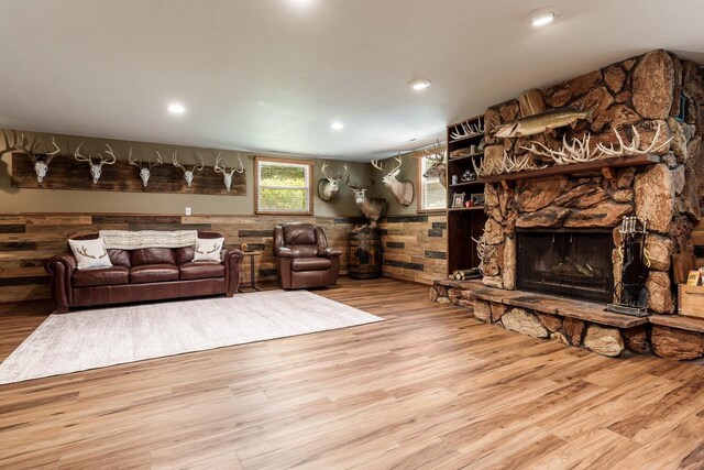 7929 N Pine View Dr, Edgerton, WI 53534 - living room featuring wood finished floors, a stone fireplace, recessed lighting, wooden walls, and a wainscoted wall