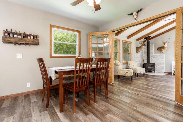 7929 N Pine View Dr, Edgerton, WI 53534 - dining space featuring a wood stove, ceiling fan, wood finished floors, and baseboards