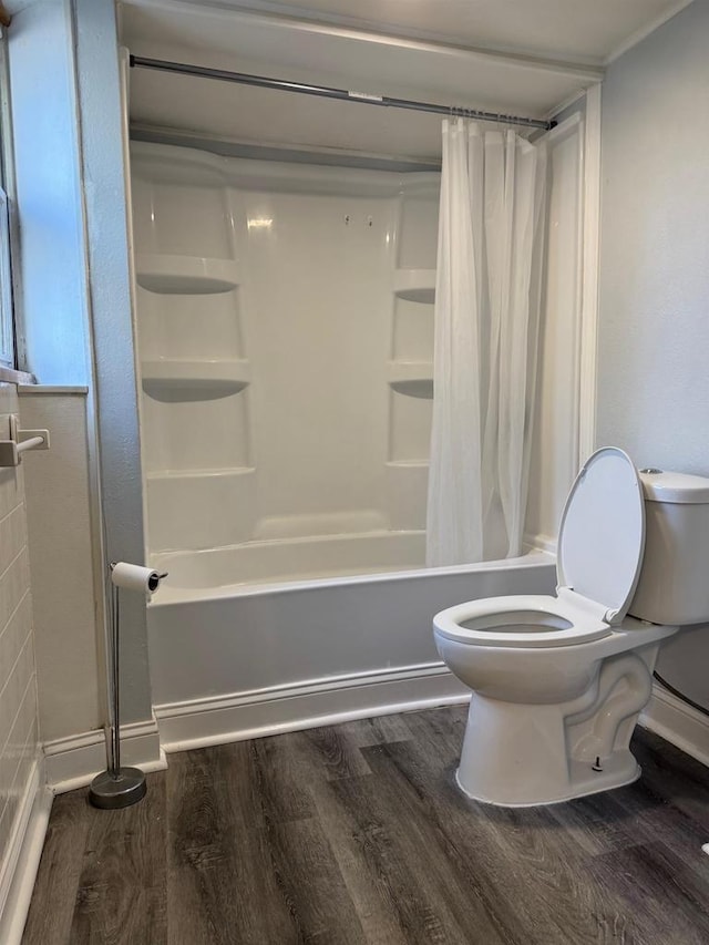 1952 S Wisconsin Ave, Beloit, WI 53511 - bathroom featuring toilet, wood finished floors, shower / bath combination with curtain, and baseboards