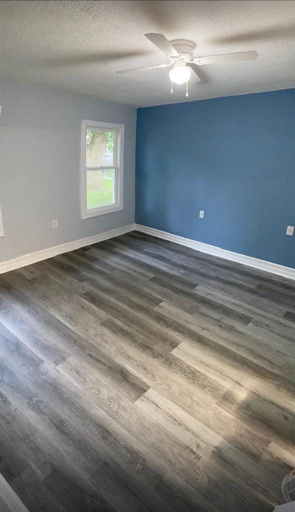 1952 S Wisconsin Ave, Beloit, WI 53511 - empty room with dark wood-style flooring, ceiling fan, baseboards, and a textured ceiling