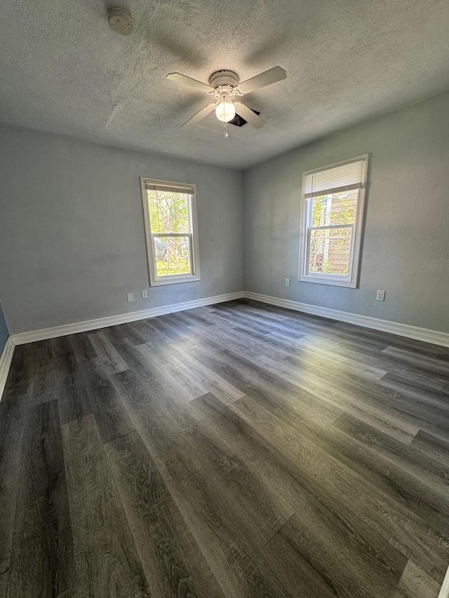 1952 S Wisconsin Ave, Beloit, WI 53511 - empty room with plenty of natural light, dark wood finished floors, a ceiling fan, a smoke detector, and a textured ceiling