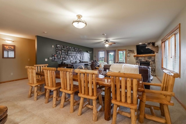 1839-6 20th Blvd Unit 0206, Arkdale, WI 54613 - dining area featuring light carpet, ceiling fan, a bar, baseboards, and a stone fireplace