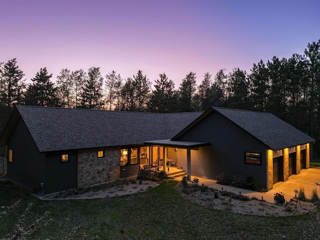 2191 County Road G, Nekoosa, WI 54457 - back of property with a shingled roof, a yard, a porch, stone siding, and concrete driveway
