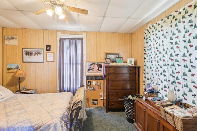 604 9th Ave, Baraboo, WI 53913 - bedroom with a drop ceiling, dark colored carpet, wooden walls, and ceiling fan