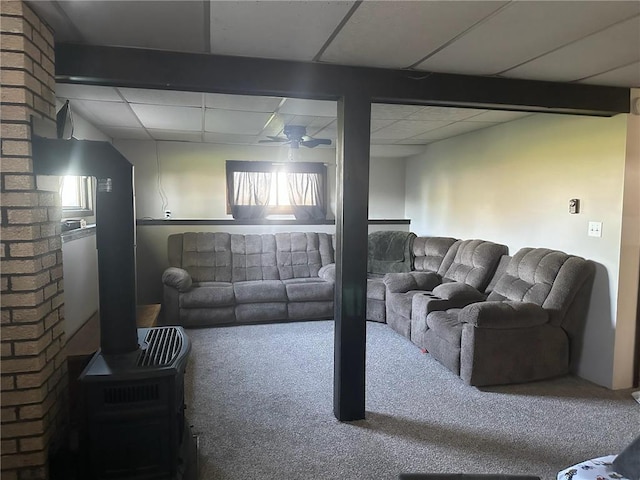 E7065 County Road B, Colfax, WI 54730 - carpeted living room featuring a paneled ceiling, ceiling fan, and a wood stove