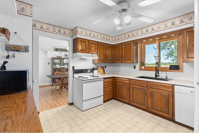 E7065 County Road B, Colfax, WI 54730 - kitchen with white appliances, a sink, under cabinet range hood, light countertops, and a textured ceiling