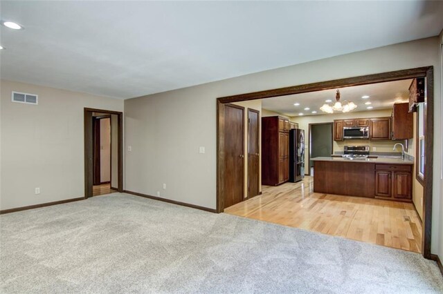 1206 Nixon Ave, Eau Claire, WI 54701 - kitchen with stainless steel microwave, range, black refrigerator with ice dispenser, light carpet, and baseboards