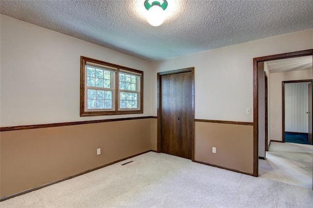 1206 Nixon Ave, Eau Claire, WI 54701 - unfurnished bedroom featuring a textured ceiling, carpet, a closet, and baseboards