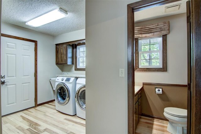 1206 Nixon Ave, Eau Claire, WI 54701 - laundry area featuring healthy amount of natural light, independent washer and dryer, light wood finished floors, a textured ceiling, and baseboards