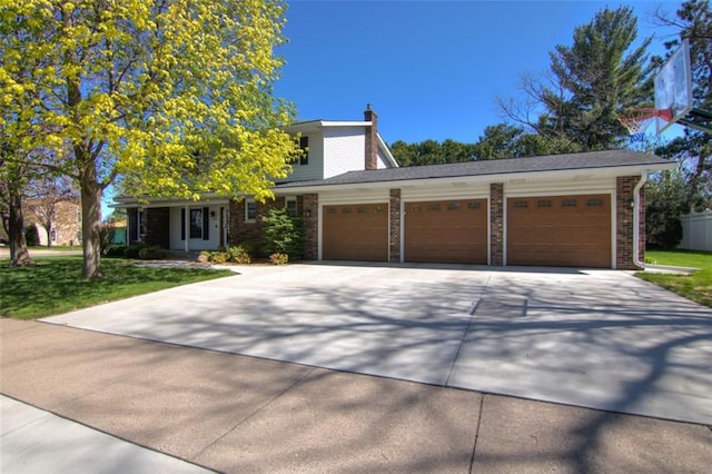 1206 Nixon Ave, Eau Claire, WI 54701 - view of front of property featuring driveway, an attached garage, a chimney, brick siding, and a front yard