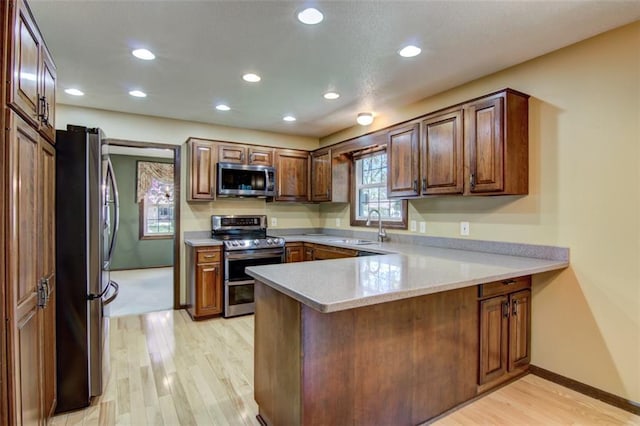 1206 Nixon Ave, Eau Claire, WI 54701 - kitchen with stainless steel appliances, a sink, a peninsula, light wood-style flooring, and recessed lighting