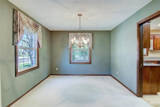1206 Nixon Ave, Eau Claire, WI 54701 - unfurnished dining area featuring a chandelier, light carpet, baseboards, and a textured ceiling
