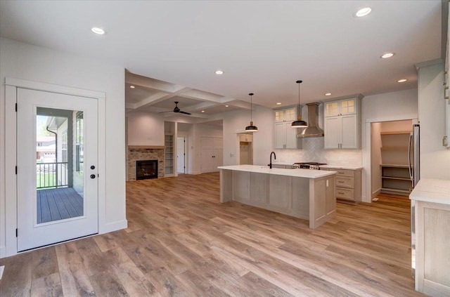 713 Kennedy St, Sauk City, WI 53583 - kitchen featuring wall chimney range hood, recessed lighting, light wood-type flooring, decorative backsplash, and light countertops