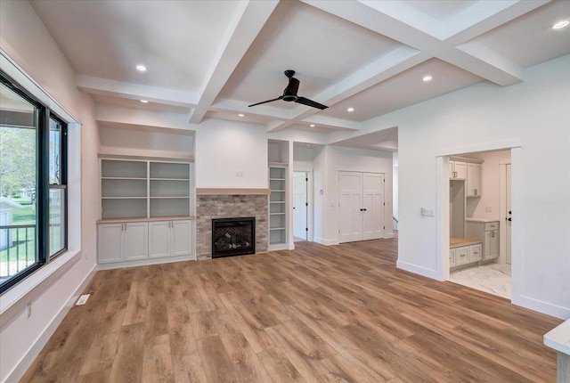 713 Kennedy St, Sauk City, WI 53583 - unfurnished living room with a ceiling fan, light wood-style flooring, beam ceiling, baseboards, and a fireplace