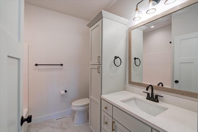713 Kennedy St, Sauk City, WI 53583 - full bath with toilet, baseboards, marble look tiles, and vanity