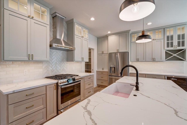 713 Kennedy St, Sauk City, WI 53583 - kitchen featuring stainless steel appliances, a sink, wall chimney range hood, hanging light fixtures, and tasteful backsplash