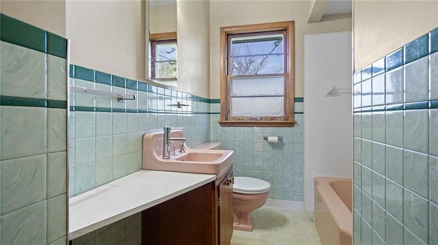 1408 E Lexington Blvd, Eau Claire, WI 54701 - bathroom featuring tile walls, tile patterned flooring, a tub to relax in, toilet, and vanity