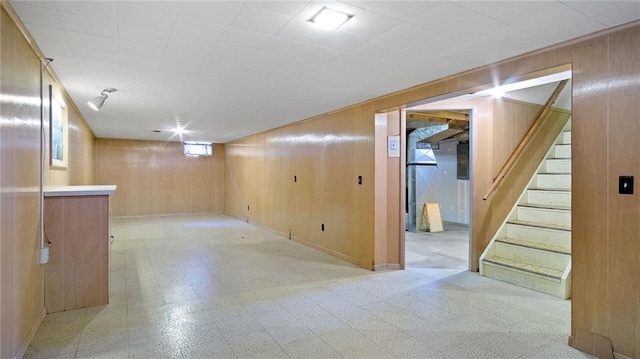 1408 E Lexington Blvd, Eau Claire, WI 54701 - below grade area featuring stairs, light flooring, and wood walls