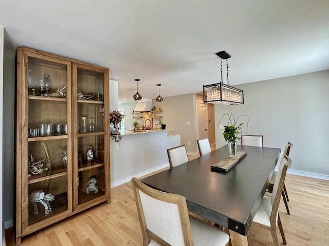 1421 N Golden Lake Rd, Summit, WI 53066 - dining area with light wood-type flooring, a chandelier, and baseboards