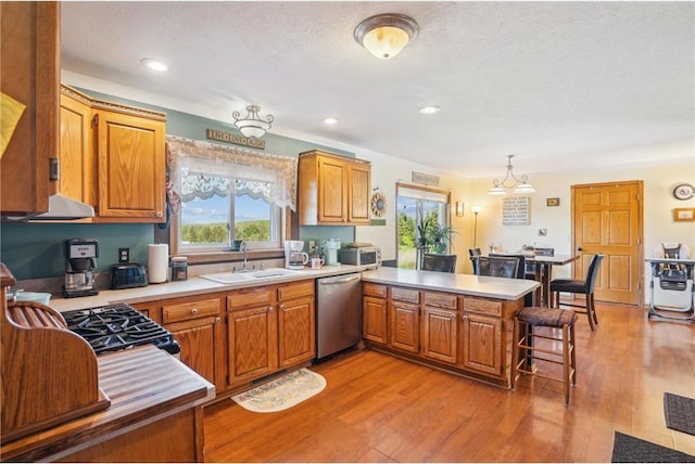2136 62nd St, Somerset, WI 54025 - kitchen featuring stainless steel dishwasher, a sink, a peninsula, light countertops, and recessed lighting