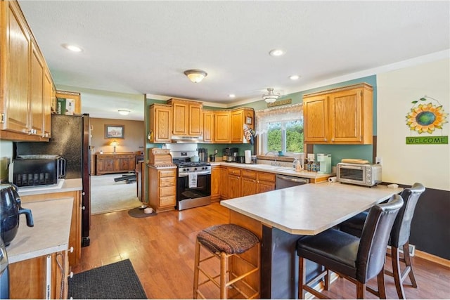 2136 62nd St, Somerset, WI 54025 - kitchen featuring stainless steel appliances, a peninsula, a sink, a kitchen breakfast bar, and recessed lighting