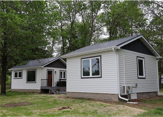 11445 State Highway 48, Luck, WI 54853 - ranch-style house with metal roof, a cooling unit, a front lawn, and board and batten siding