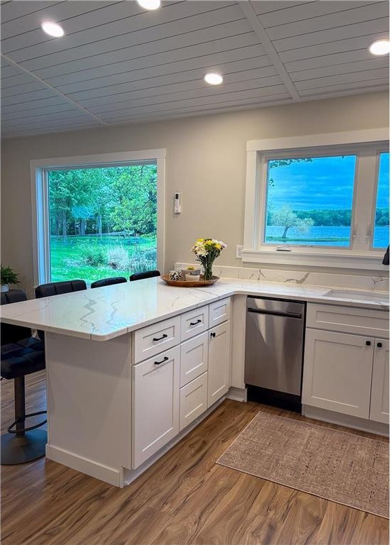 11445 State Highway 48, Luck, WI 54853 - kitchen featuring stainless steel dishwasher, a peninsula, a breakfast bar area, white cabinetry, and recessed lighting