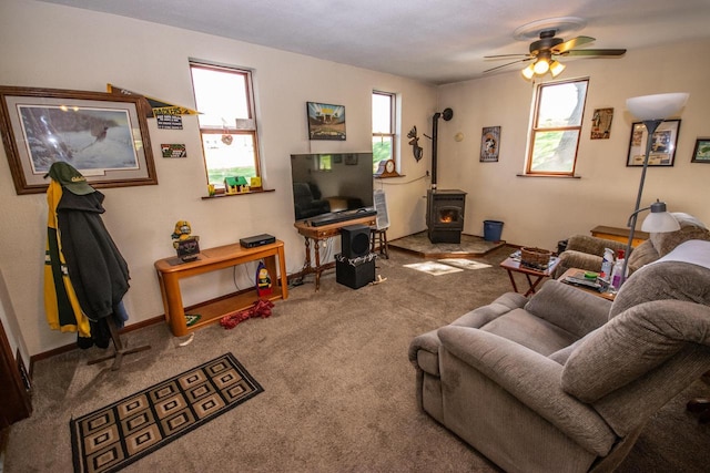 5291 Deer Rd, Hartford, WI 53027 - carpeted living area featuring a wood stove, a ceiling fan, and baseboards